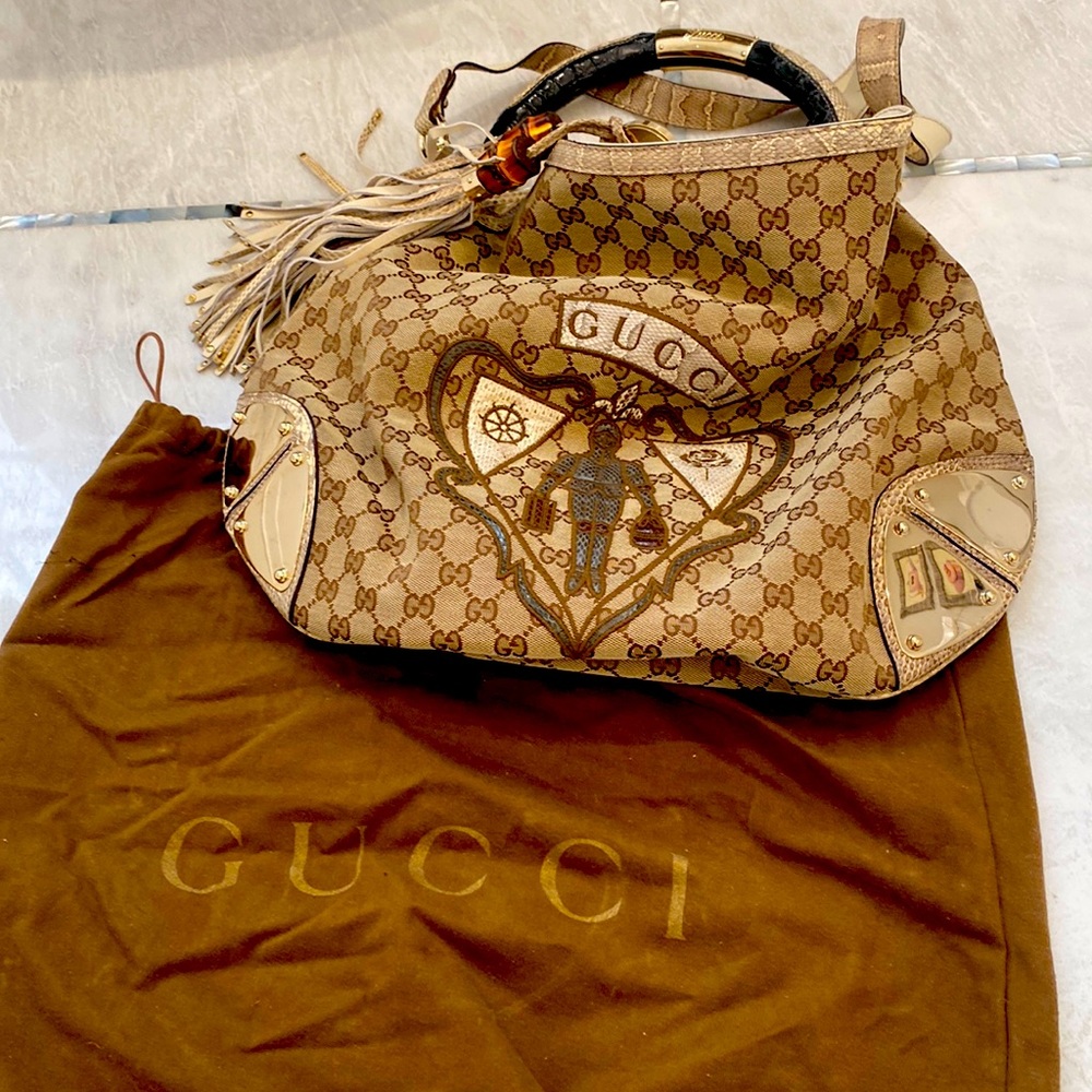 Gucci handbag with snakeskin handles and crossbody strap.